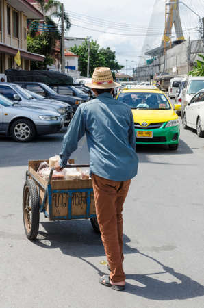 BANGKOK, THAILAND - SEPTEMBER 18, 2016: People with carts selling street against a taxi on the street in Bangkok, Thailand.のeditorial素材