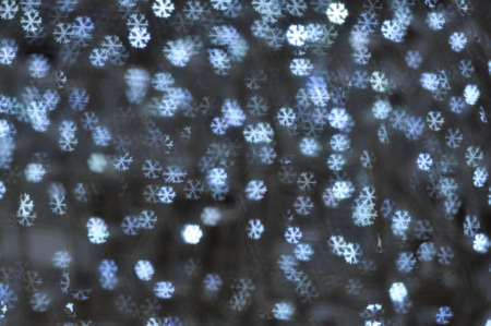Beautiful holiday background with silver snowflakes defocused lightsの写真素材