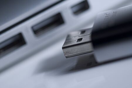 a USB stick in front of a USB portの写真素材