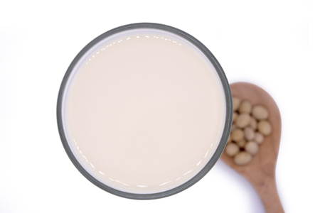Soy beans on white background high protein Close-up Selective focus seeds Soya bean pulses in a wooden spoon (Glycine max (L.) Merr.)の写真素材
