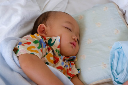 Cute asian baby sleeping on the bed in the bedroom.の写真素材