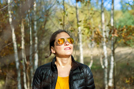Girl with sunglasses in autumn in beautiful dayの写真素材