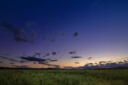 harvested field under burning clouds in bulgariaの写真素材