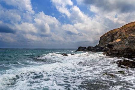 Waves breaking on rocky coast in summerの写真素材