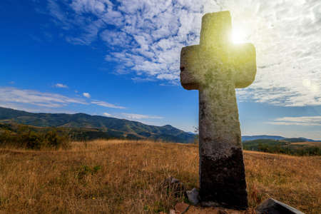 Christian cross on a mountains with a sky backgroundの写真素材