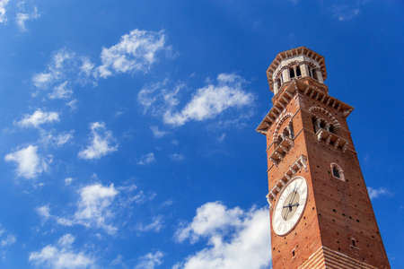 Close-up view on Lamberti tower with clock in Verona city in Italyの写真素材