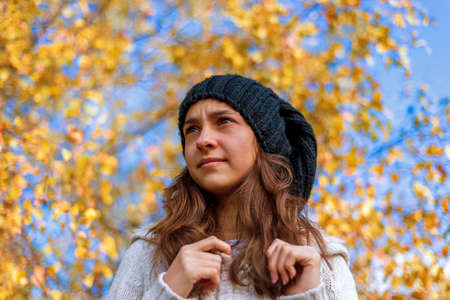 Girl relaxing in autumn park in beautiful dayの写真素材
