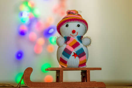 Christmas background with a snowman sitting on a sledの写真素材