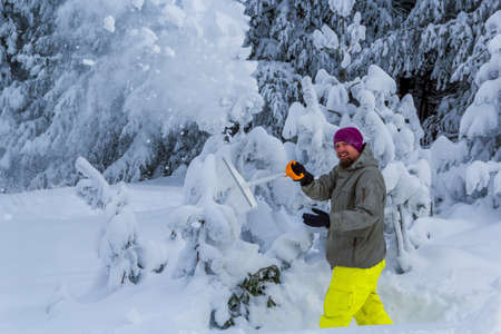man clears snow from the mountains in decemberの写真素材