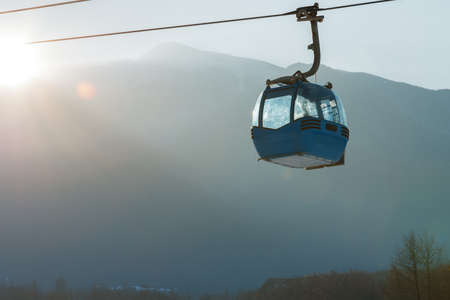 Ropeway and cable car transport system for skiers in sunsetの写真素材
