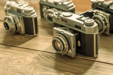 Vintage cameras and lenses on wooden background at summer days