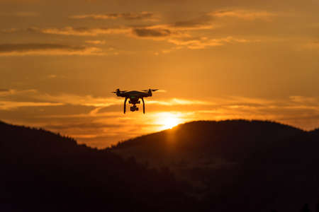 drone quad copter with digital camera at sunset ready to fly for surveillanceの写真素材
