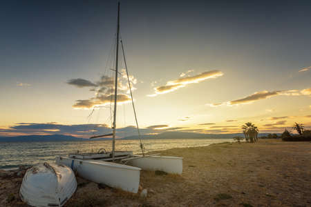 Sailboat on the beach at sunset in Greeceの写真素材