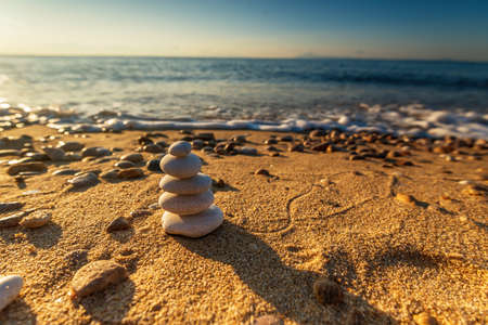Stones Balance in sunrise at sea in summerの写真素材