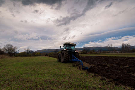 Tractor plowing fields. Preparing land for sowing in autumn.の写真素材