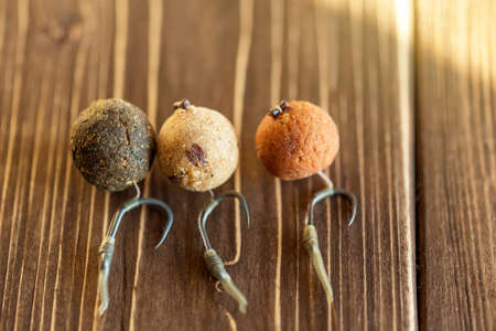 Carp fishing. Different of carp boilies and accessories for carp fishing isolated on wooden