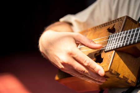 Close up male fingers of guitarist strumming the strings.の写真素材