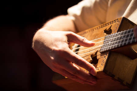 Close up male fingers of guitarist strumming the strings.の写真素材