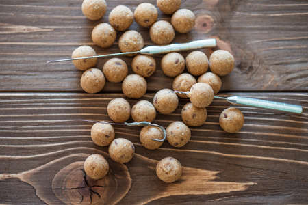 Carp fishing. Different of carp boilies and accessories for carp fishing isolated on wooden
