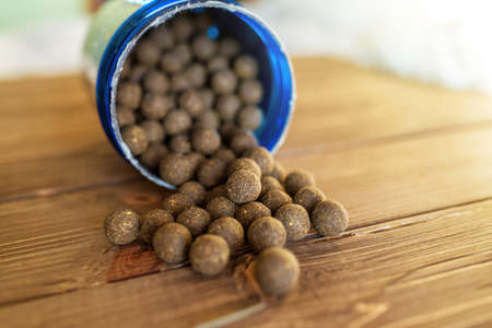 Carp fishing. Different of carp boilies and accessories for carp fishing isolated on wooden