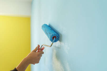 Decorator's hand painting wall with roller.の写真素材