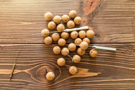 Carp fishing. Different of carp boilies and accessories for carp fishing isolated on wooden...