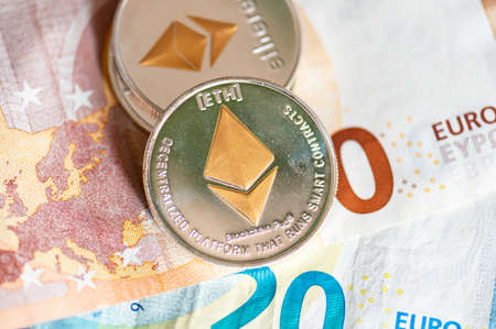 Close-up of Ethereum coins on Euro banknotes. Crypto currency ETC.