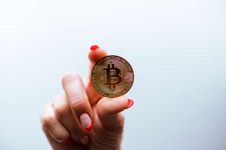 Cryptocurrency golden bitcoin coin in woman hand - symbol of crypto currency - electronic virtual money.の写真素材