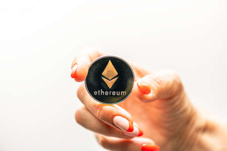 Golden Ethereum in a woman hand, Digital symbol of a new virtual currency.の写真素材