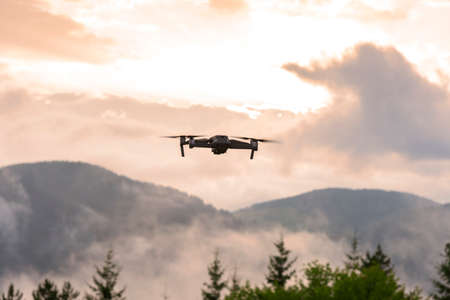 Drone with camera flying over mountain fields. Aerial photography and videography.の写真素材