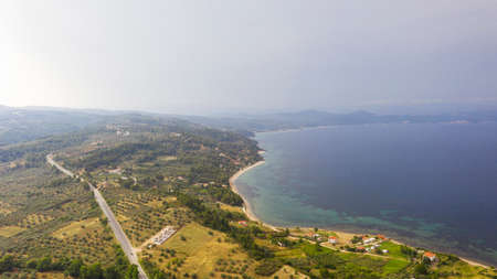 Visit majestic beaches in Greece. Aerial view of the idyllic seascape on the Sithonia peninsula in Halkidiki. High above the roofs of the authentic resort villageの写真素材