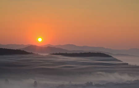 Fog mountain and sunrise in Thailandの写真素材