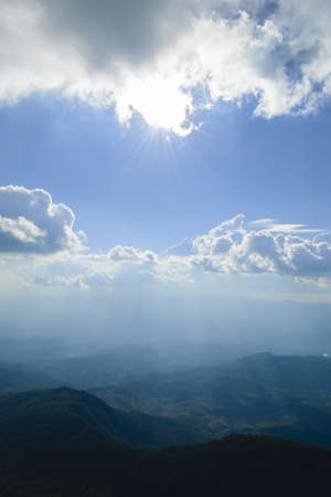 Mountain terrain in a sea of mist, on cloudy sky with sunlight beam. Beautiful panoramic view of highland.の写真素材