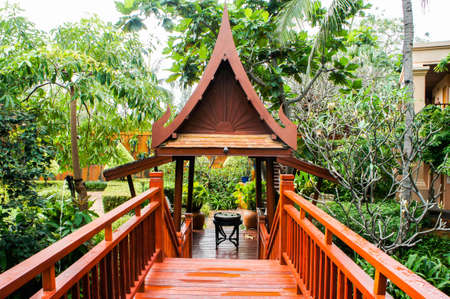 Wooden bridge, walkway, through Thai style pavilion, in the hotel garden.の写真素材