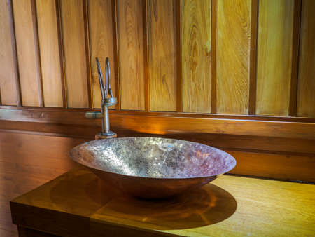 Vintage brass wash basin and faucet in wooden bathroom.の写真素材