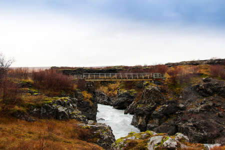 Steel bridge across the water stream in hraunfossar, Iceland.の写真素材