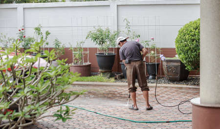 Bangkok, Thailand - December 5, 2016: Man cleaning the ground floor with high pressure waterのeditorial素材