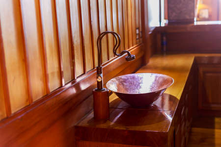 Vintage brass wash basin and faucet in wooden bathroom.の写真素材