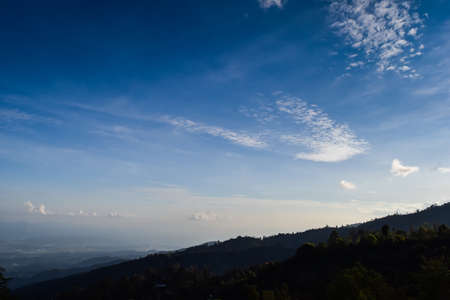 Mountain terrain in a sea of mist, on cloudy sky with sunlight beam. Beautiful panoramic view of highland.の写真素材