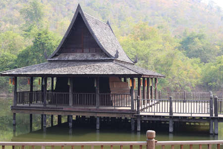Thai old style wooden pavilion in the pond near the mountain.のeditorial素材