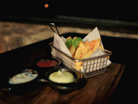 Basket of French fries on the table at the beach during night time.