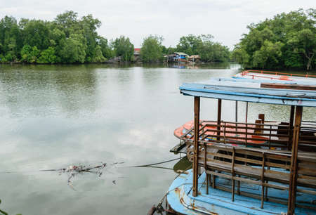 Small local ferry boat docking along the river, waiting for passengersの写真素材