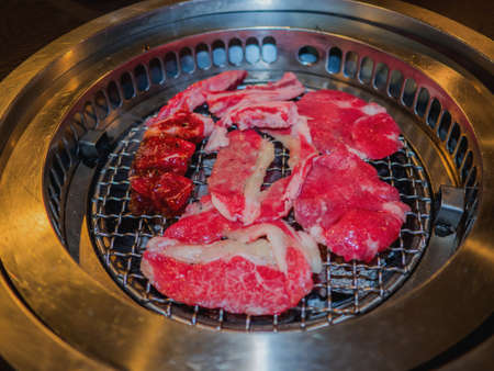 Sliced beef on hot charcoal grill, yakiniku restaurant.の写真素材