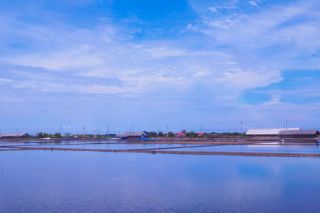 Salt field with shanty in panorama view, with blue ocean color background. Feeling of being immense and lonely.の写真素材