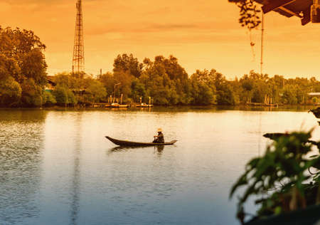 Man rowing a small wooden boat, concept for life along the river in Asia.の写真素材