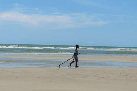 Hua-Hin, Prachuabkirikhan, Thailand â April 17, 2017: young fisherman using the clam dredges at the beach.のeditorial素材