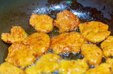Deep fried fish cake in the pan, on stove, a famous Thai traditional food.の写真素材