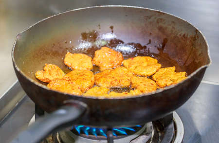 Deep fried fish cake in the pan, on stove, a famous Thai traditional food.の写真素材