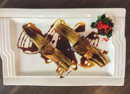 Japanese Grilled eel and Foie gras sushi served with teriyaki soy sauce with vegetable decoration.の写真素材