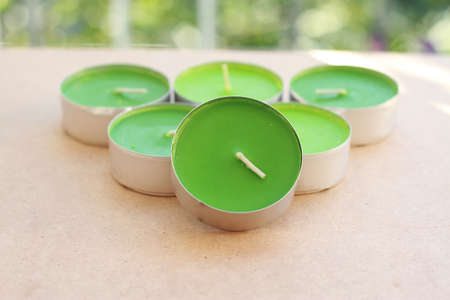 Green Aromatic Candles on wooden board with green bokeh behindの写真素材